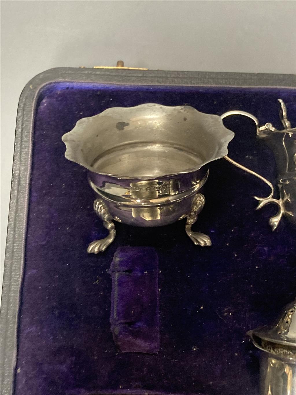 An Edwardian cased seven piece silver condiment set, Birmingham, 1907, (lacking spoons).